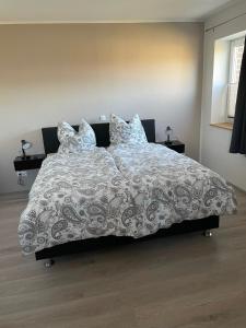 Una cama con manta y almohadas. en Jahn Apartments, en Barßel
