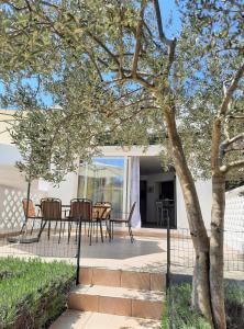a patio with a table and chairs under a tree at Apartment Mato in Barbariga