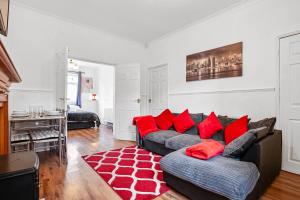 ein Wohnzimmer mit einem Sofa und roten Kissen in der Unterkunft Staywhenever MS- 4 Bedroom House, King Size Beds, Sleeps 9 in Stoke on Trent