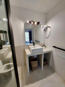 ein Bad mit einem Waschbecken und einem Spiegel in der Unterkunft Résidence E CIME ASCO in Asco