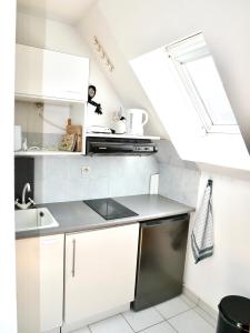 a kitchen with white cabinets and a skylight at Cabourg Mathilde in Cabourg