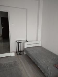 a white room with a bed and a table at APARTAMENT CENTRUM Węgorzewa in Węgorzewo
