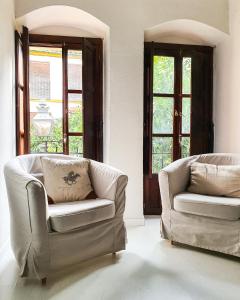 コルドバにあるCasa con Terraza San Fernandoのリビングルーム(椅子2脚、窓2つ付)