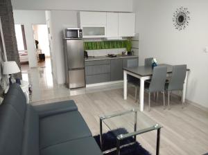 a kitchen and living room with a table and chairs at APARTAMENT CENTRUM Węgorzewa in Węgorzewo