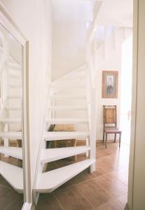 a white staircase in a room with a mirror at Linnuse Apartement in Haapsalu