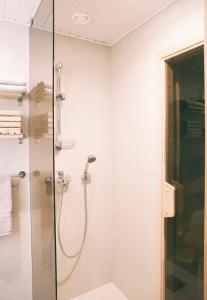 a shower with a glass door in a bathroom at Linnuse Apartement in Haapsalu