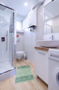 uma casa de banho com um lavatório, um chuveiro e um WC. em Apartament Deluxe Arcon Double em Siemianowice Śląskie