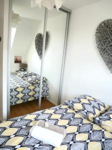 1 Schlafzimmer mit 2 Betten und einem Wandspiegel in der Unterkunft Cabourg Mathilde in Cabourg