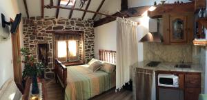 - une chambre avec un lit et un mur en pierre dans l'établissement Casa Miguel, à Olea