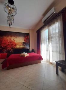 Schlafzimmer mit einem roten Bett und einem großen Fenster in der Unterkunft ELITE VIP - Apartment with sea VIEW - swimming pool - BBQ terrace - near BEACH in Hurghada