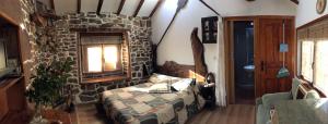 a room with a bed and a stone wall at Casa Miguel in Olea