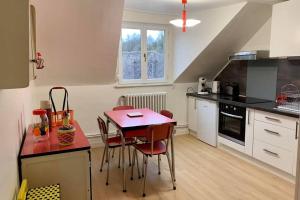 - une cuisine avec une table rouge et des chaises dans l'établissement Appartement Vintage avec vue sur le château, à Pierrefonds