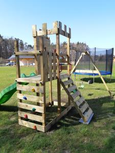 a wooden playground with a slide and swings at Choczewski Zakątek in Choczewo