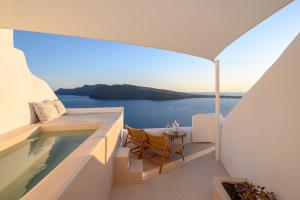 a view of the ocean from the balcony of a house at Canvas Suites in Oia