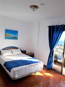 Schlafzimmer mit einem Bett und einem Fenster in der Unterkunft casa mariposa in Playa de Santiago
