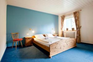 a bedroom with a wooden bed and a blue wall at Sportland Inn in Unterpeischlach