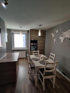 - une cuisine et une salle à manger avec une table et des chaises dans l'établissement Edžio apartamentai, à Palanga