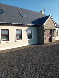 a house with a gravel driveway in front of it at Killard House in Caherlean