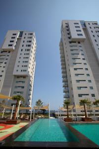 two tall buildings with a swimming pool in between them at Olympic Residence Deluxe Apartments in Limassol