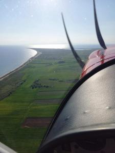 a view of the wing of an airplane flying over the ocean at GERANI apartments in Órmos