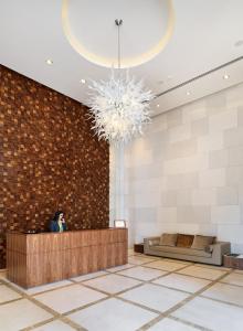 a woman standing at a counter in a lobby at Olympic Residence Deluxe Apartments in Limassol