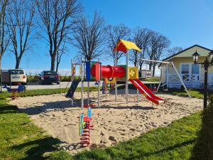 a playground with a slide in the sand at Holiday Camp Sarbinowo in Sarbinowo