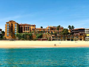 vistas a una playa con edificios en el fondo en Rigat Park & Spa Hotel - Adults Recommended, en Lloret de Mar