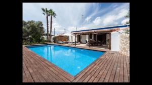 a large blue swimming pool next to a house at Can Ballet in Ibiza Town