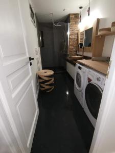uma pequena cozinha com máquina de lavar e secar roupa em Loft 100m2 neuf entièrement équipée em Callac