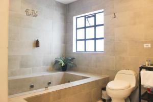 a bathroom with a tub and a toilet and a window at 574 Hotel in Medellín