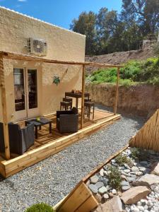 a patio with chairs and tables on a house at Maisonnette A Santa Ghjulia entre Mer & Montagne in Volpajola