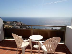 einen Balkon mit einem Tisch, Stühlen und Meerblick in der Unterkunft casa mariposa in Playa de Santiago