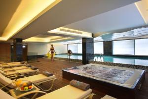 a room with a swimming pool and a woman in the background at Olympic Residence Deluxe Apartments in Limassol