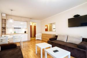 ein Wohnzimmer mit einem Sofa und einem Tisch in der Unterkunft Apartment Sand Castle with free parking in Świnoujście