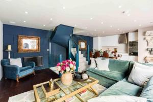 een woonkamer met een groene bank en blauwe muren bij Exceptional, boutique retreat Bath road Cheltenham in Cheltenham