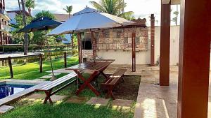 泰巴的住宿－Casa Taíba Beach Resort，野餐桌和带雨伞的长凳