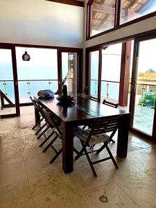 uma sala de jantar com uma mesa de madeira e cadeiras em Casa Taíba Beach Resort em Taíba