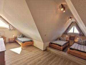 a attic room with two beds and two windows at Strandbad in Horumersiel