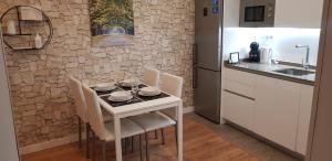 cocina con mesa blanca con sillas y fregadero en Apartamento EL CARMEN con Parking GRATIS, en Toledo