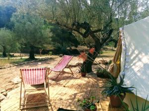 two chairs sitting on a deck next to a tent at Romantic Safari tent in Tortosa