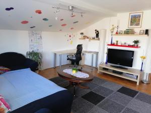 a living room with a bed and a table and a tv at at Marian's place in Spuhlja
