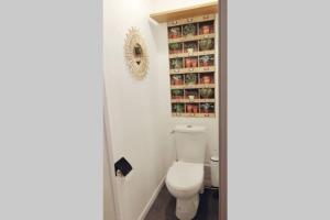 a bathroom with a toilet and a shelf with spices at L'oasis : Appartement en centre ville in Abbeville