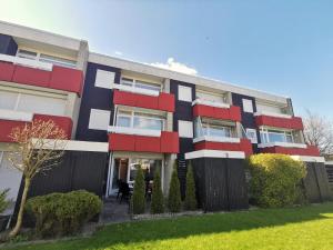 un immeuble avec des fenêtres rouges et blanches dans l'établissement Nordseegras, à Horumersiel