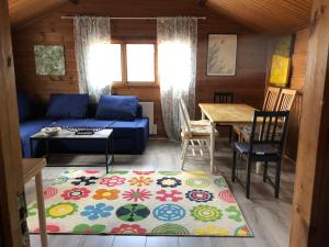 a living room with a blue couch and a table at Three Rooms stuga i stugby near National Park in Undenäs