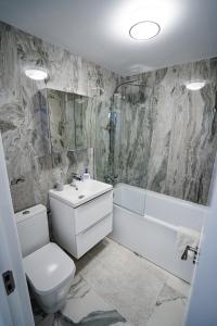 La salle de bains est pourvue de toilettes, d'un lavabo et d'une baignoire. dans l'établissement Gabi Apartament, à Suceava