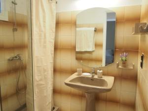 W łazience znajduje się umywalka, lustro i prysznic. w obiekcie Casa Tierra Loutses w mieście Loútsai