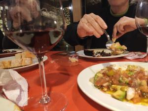 una persona che mangia a tavola con un bicchiere di vino di casa rural Sierra del Solorio (posada de Iruecha) a Iruecha Altre 27 foto