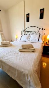 a large white bed with two towels on it at Pleasant Studio apartment, Z4 in Vanessa Complex in Peyia