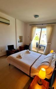 a bedroom with a large bed and a large window at Pleasant Studio apartment, Z4 in Vanessa Complex in Peyia