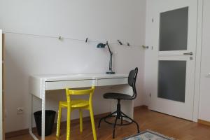 a white desk with two chairs and a lamp at Apartament Prusa in Szczawno-Zdrój